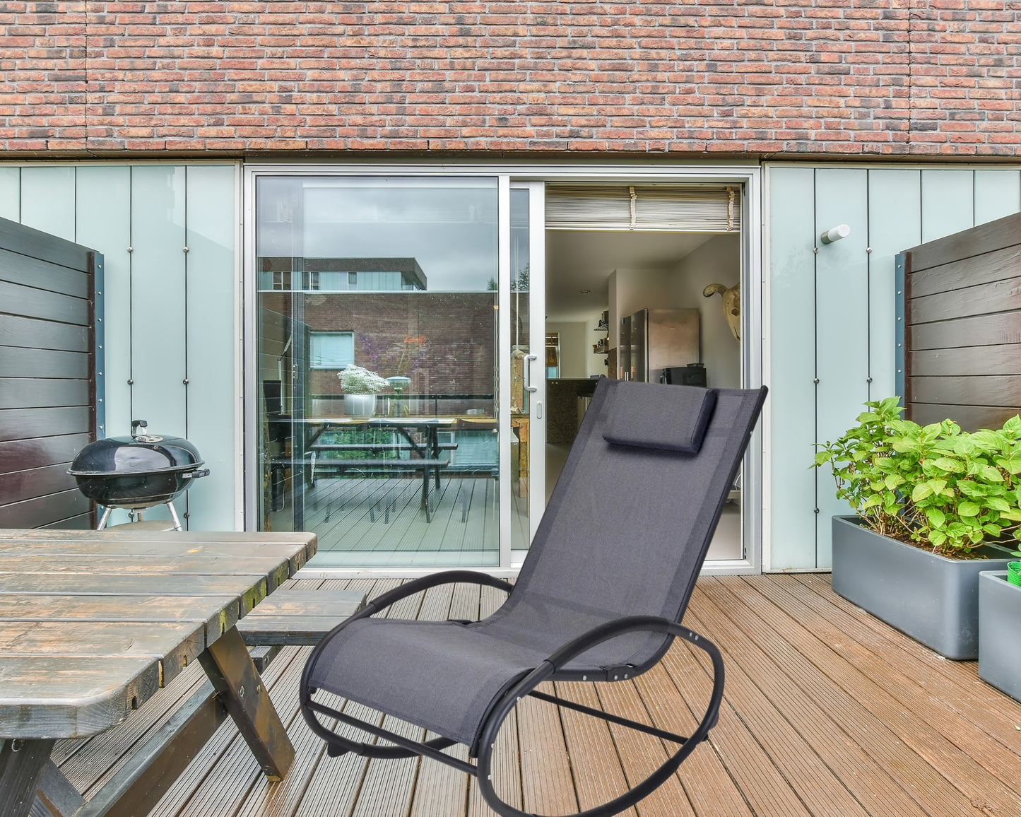 Une chaise à bascule d'extérieur sur une terrasse.